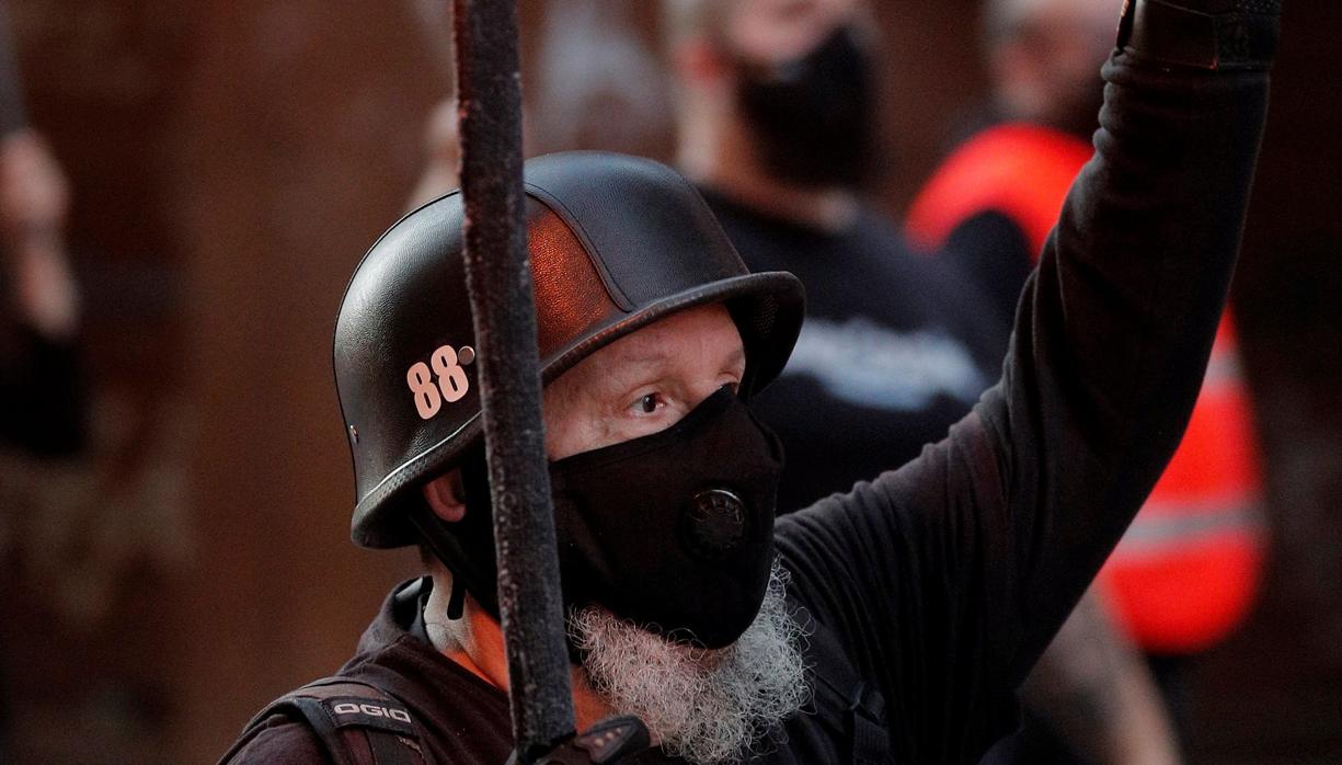 Un manifestante con una camiseta con el lema «White lives matter» realiza un gesto durante la «marcha de las antorchas» convocada por España 2000