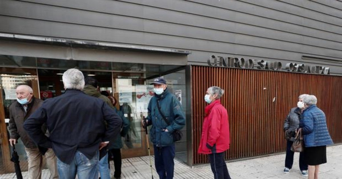 Un grupo de personas esperan a la entrada de un centro de salud de Pamplona.