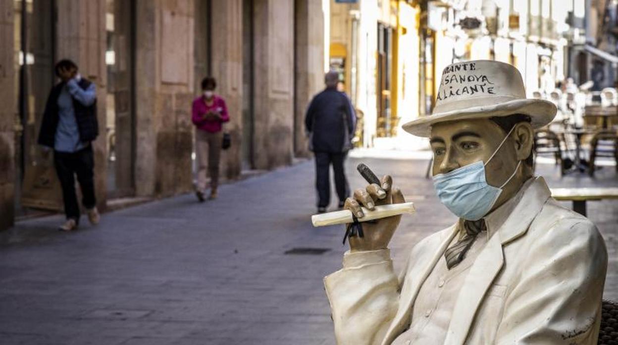 Un muñeco con mascarilla en la puerta de un restaurante alicantino, este viernes