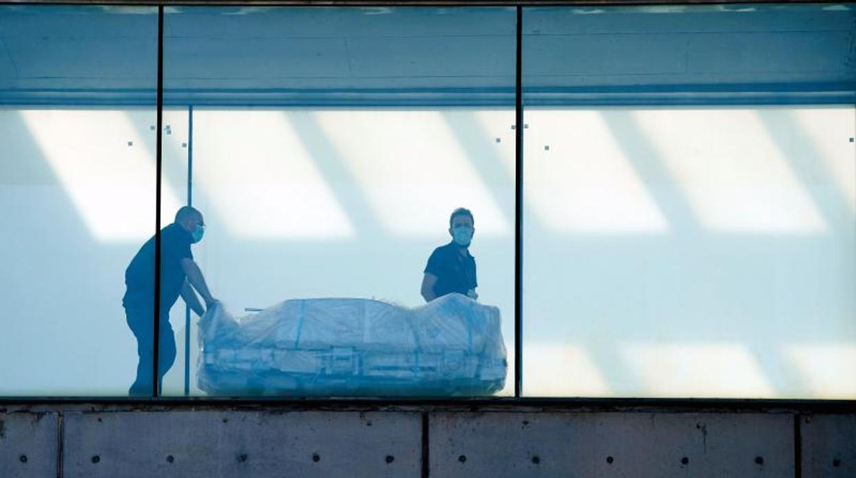 Dos celadores transportan una camilla en el Hospital del Mar