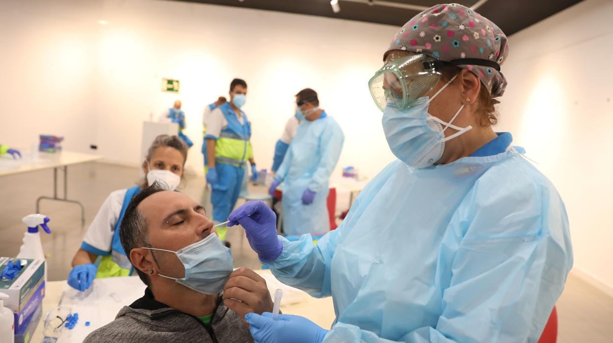 Una trabajadora sanitaria le realiza un test de antígenos a un hombre en el centro cultural Lope de Vega