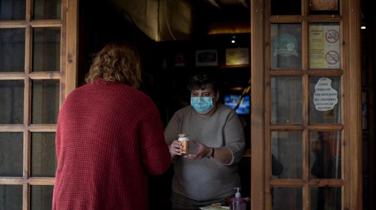 Una camarera sirve un café para llevar, este jueves en un bar de O Carballiño (Orense)