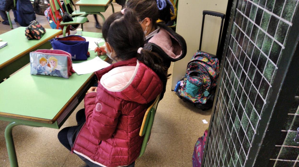 Alumnas dando clase con el abrigo puesto en un colegio madrileño/ El CSIC recomienda abrir puertas y ventanas de las aulas seis veces por hora