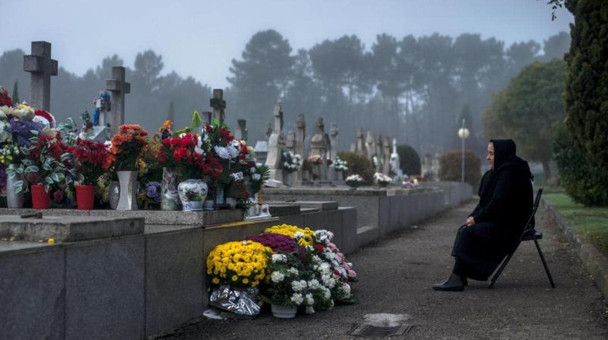 Una mujer, ante la tumba de un familiar en un cementerio orensano