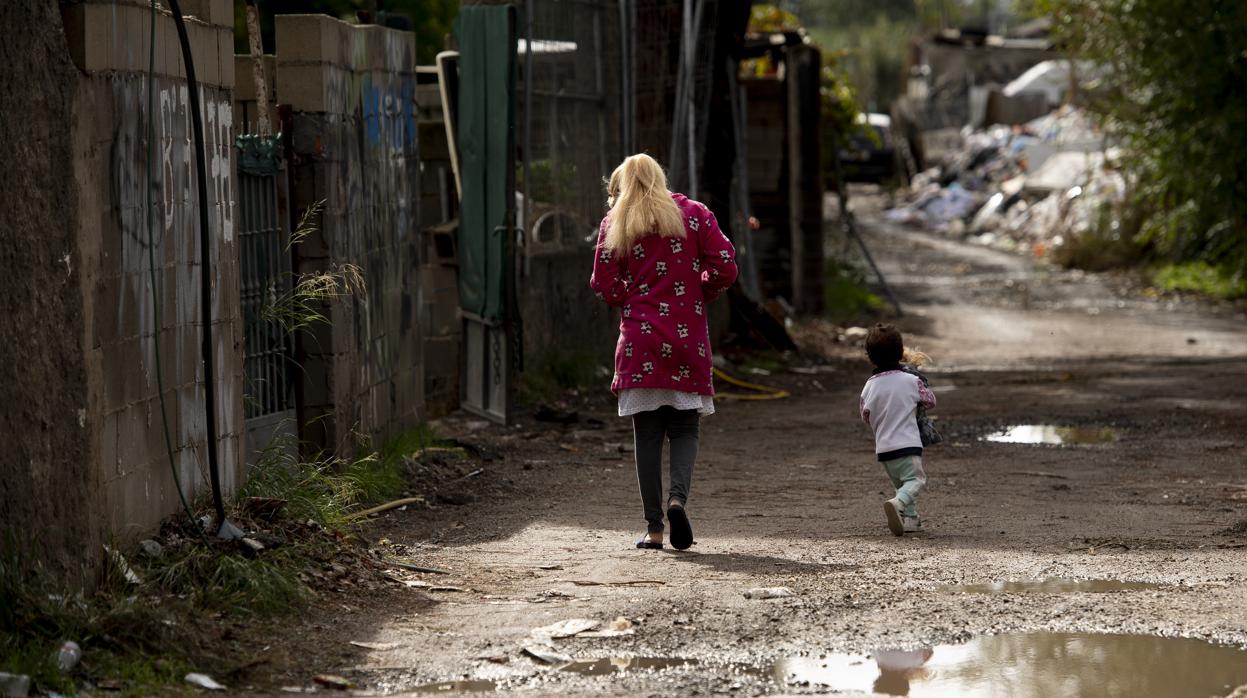 Una madre y su hija pasean por la calle principal, Esteban García, del asentamiento de Las Sabinas