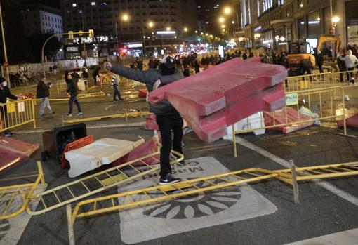 Un individuo arroja una valla de obra cerca de Callao