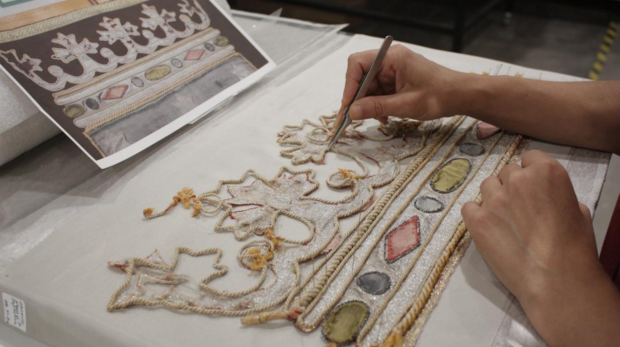 Una de las conservadoras de la Real Fábrica de Tapices de Madrid restaura el escudo de Madrid del repostero de la plaza de toros de Las Ventas