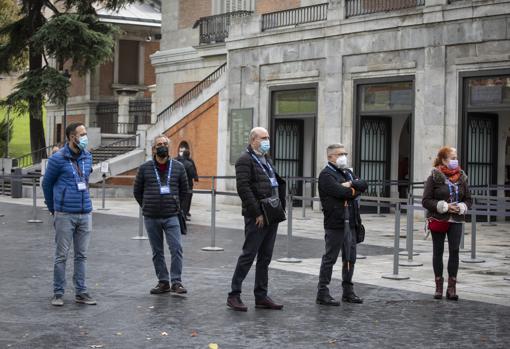 Varios guías turísticos aguardan a clientes que no llegan frente al Museo del Prado