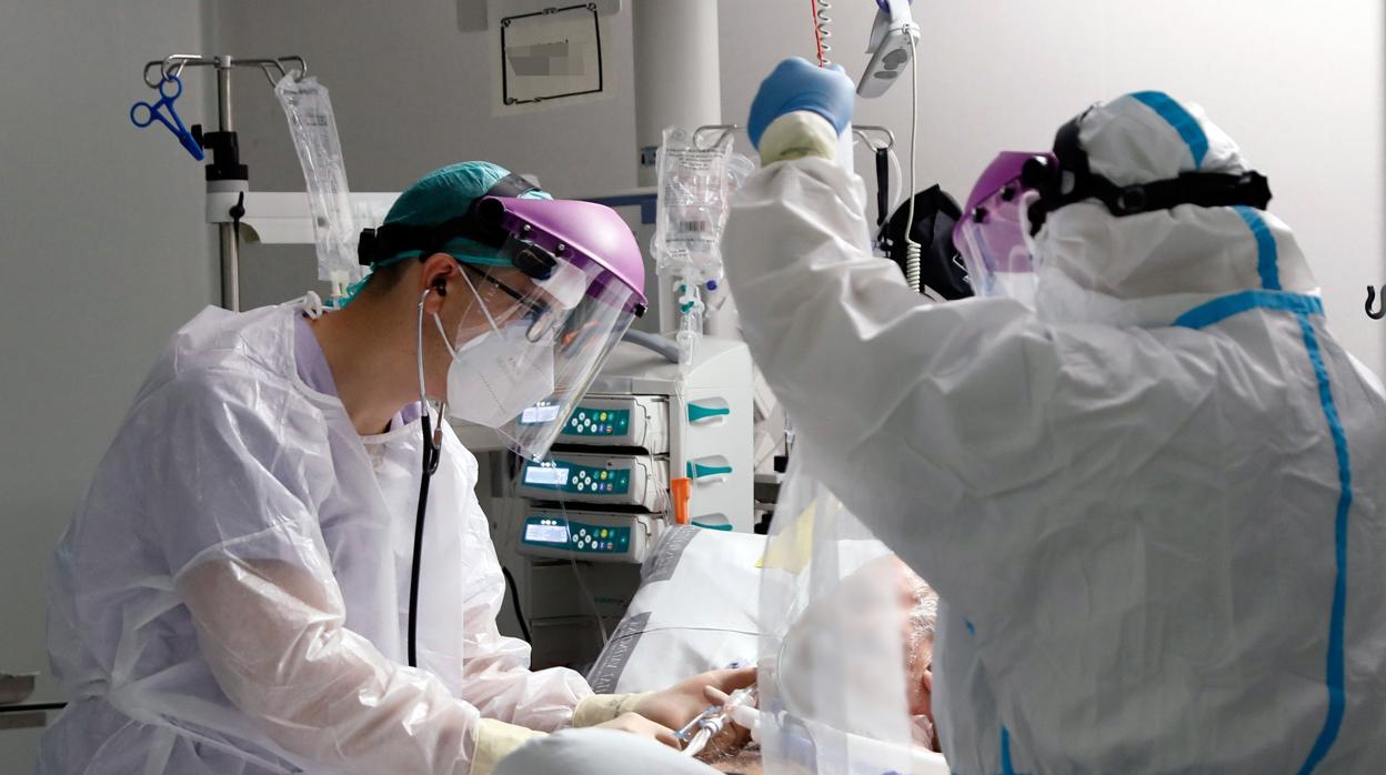 Imagen de dos sanitarios atendiendo a un paciente en la Unidad de Cuidados Intensivos del Hospital La Fe de Valencia