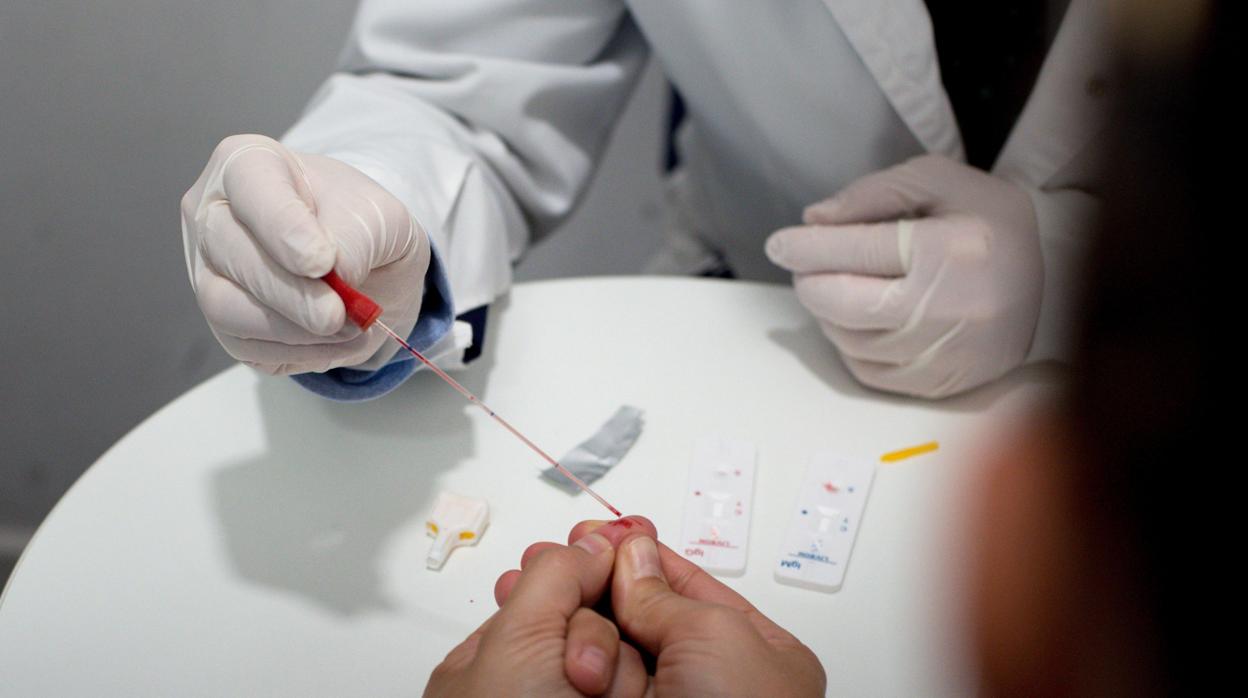 Un farmacéutico, realizando un test rápido en la provincia de Orense, pionera en esta iniciativa