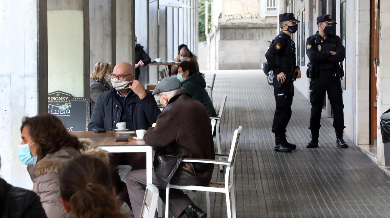 Dos Policías controlando que se cumplan las medidas de seguridad en una cafetería