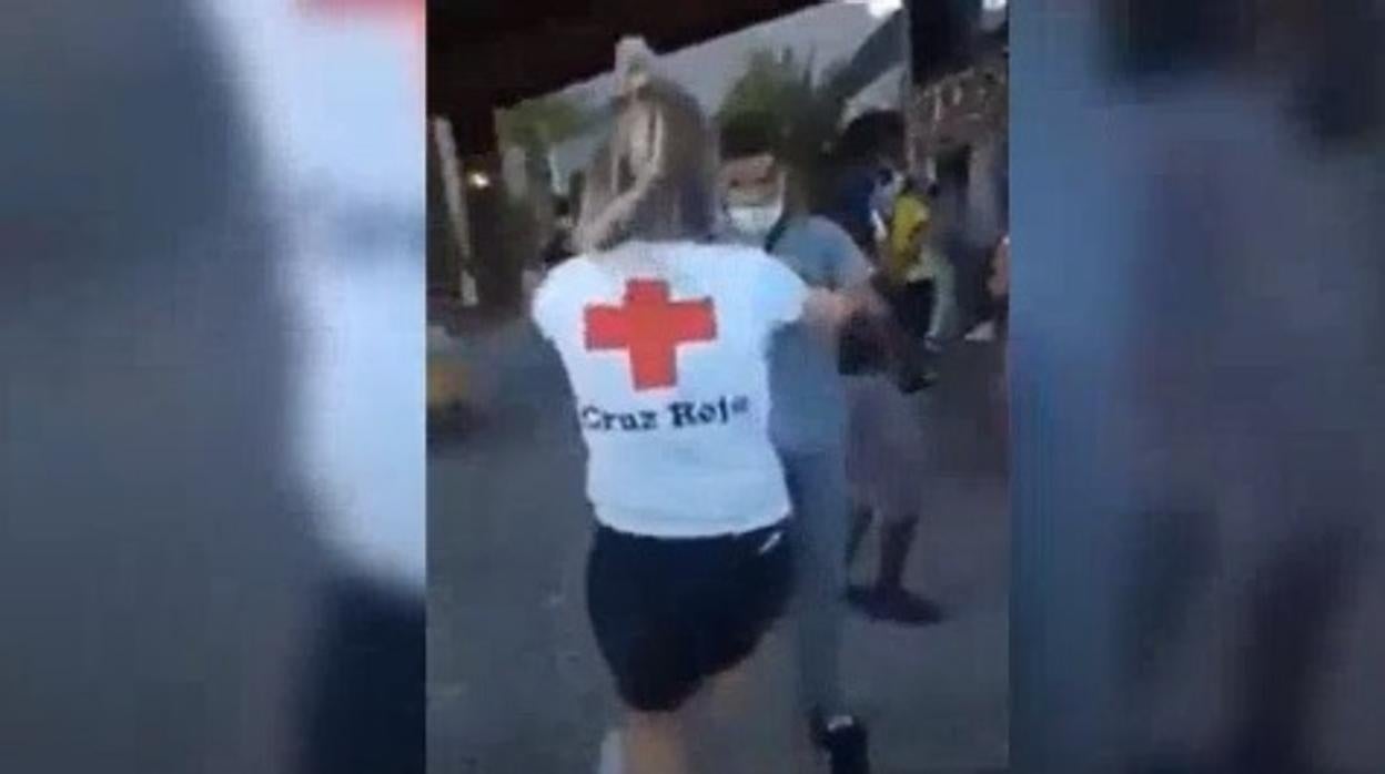 Imagen de una voluntaria de la Cruz Roja bailando con un inmigrante