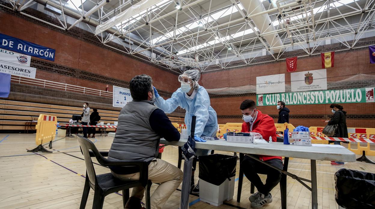 Una sanitaria realiza un test de antígenos para detección del coronavirus a un vecino de Pozuelo de Alarcón