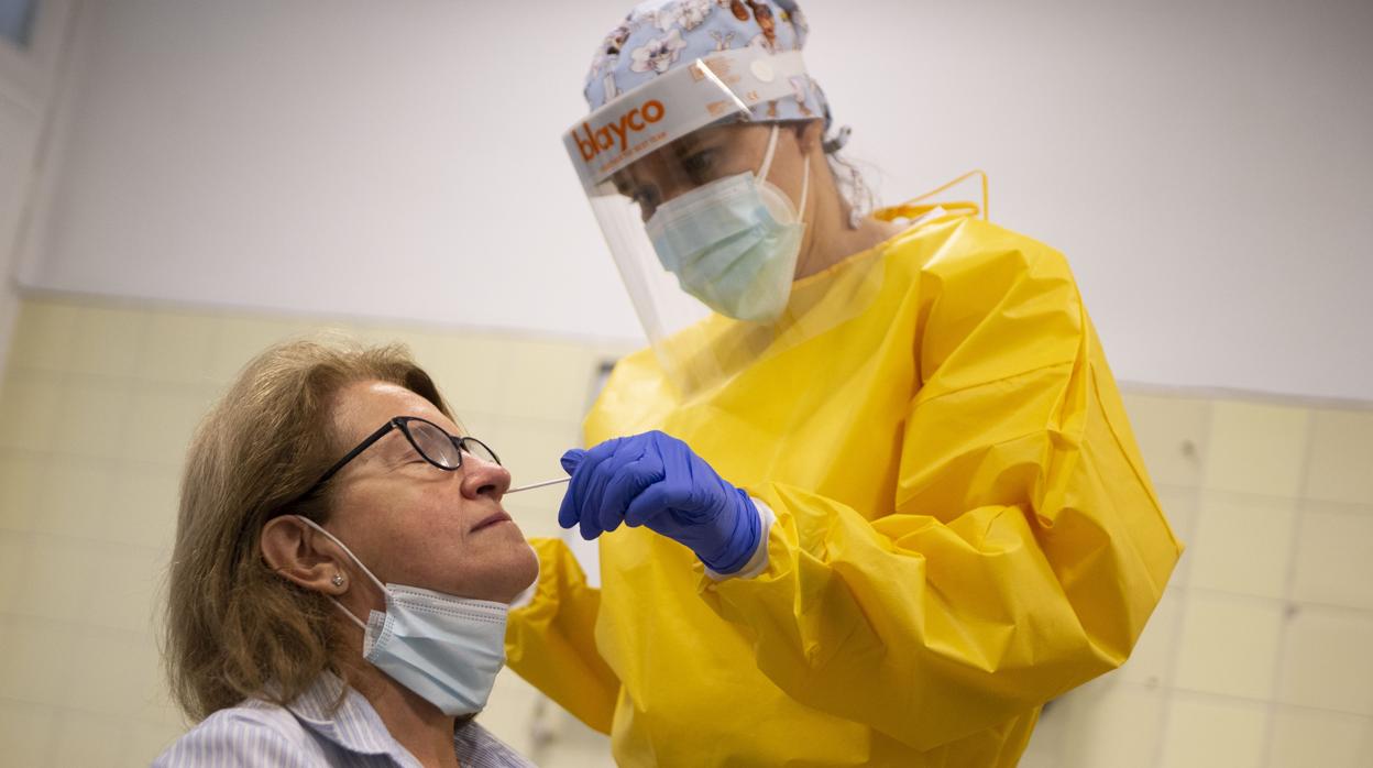 Una sanitaria realiza el test de antígenos a una mujer