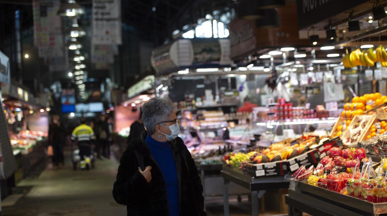 Una mujer pasea por el Mercado de La Boqueria