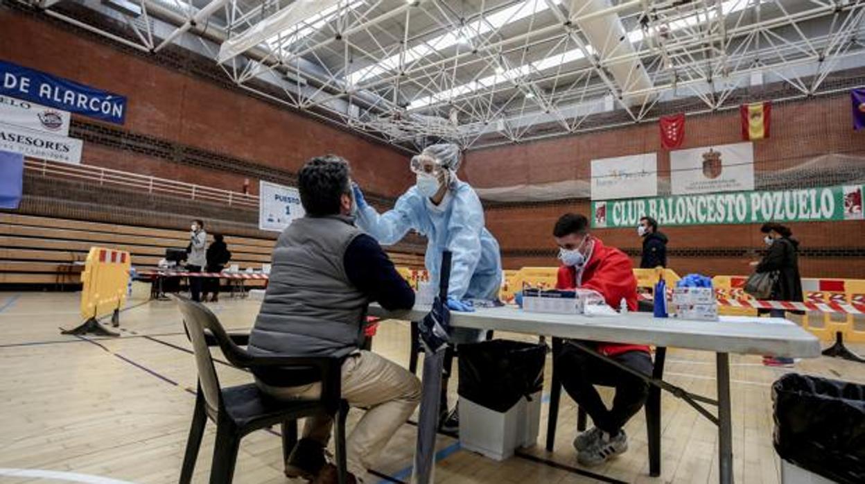 Una sanitaria realiza un test de antígenos para detección del coronavirus a un vecino de Pozuelo de Alarcón