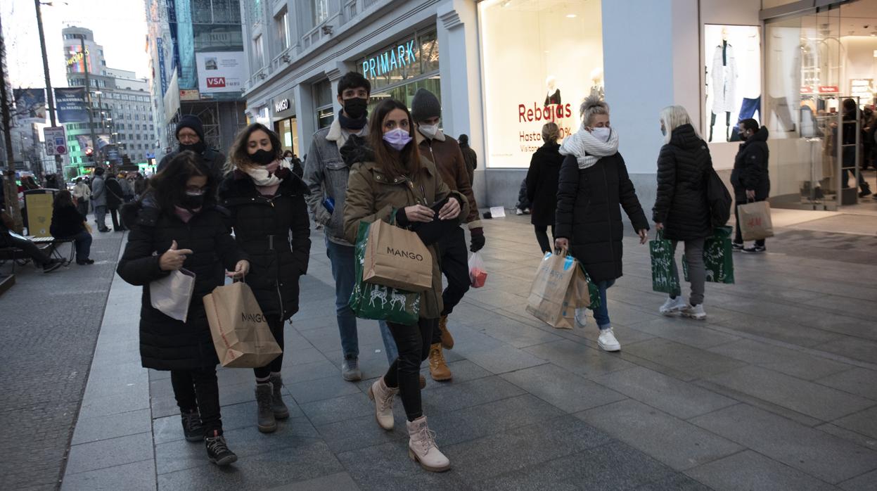 Varias personas caminan por la Gran Vía tras hacer algunas compras con rebajas ya en las tiendas