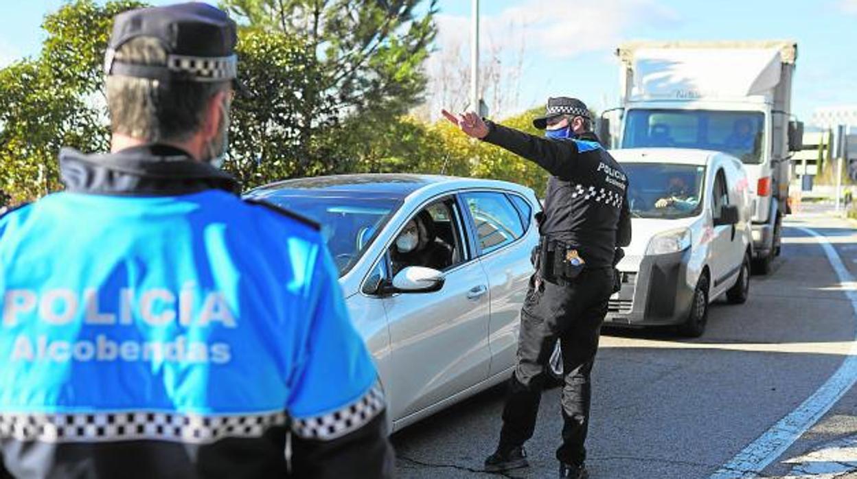 Agentes de la Policía Municipal de Alcobendas controlan el acceso a la urbanización La Moraleja, confinada hce varias semanas