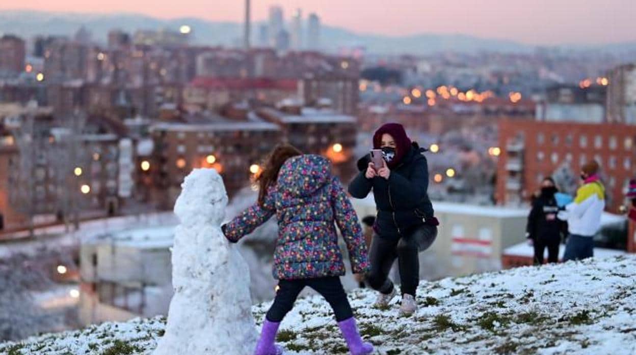 Varios niños juegan entre la nieve en el cerro del Tío Pío, ayer en la capital