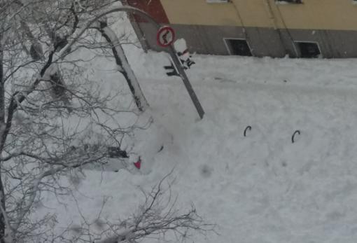 Coche sepultado por la nieve en una calle de Ciudad Lineal