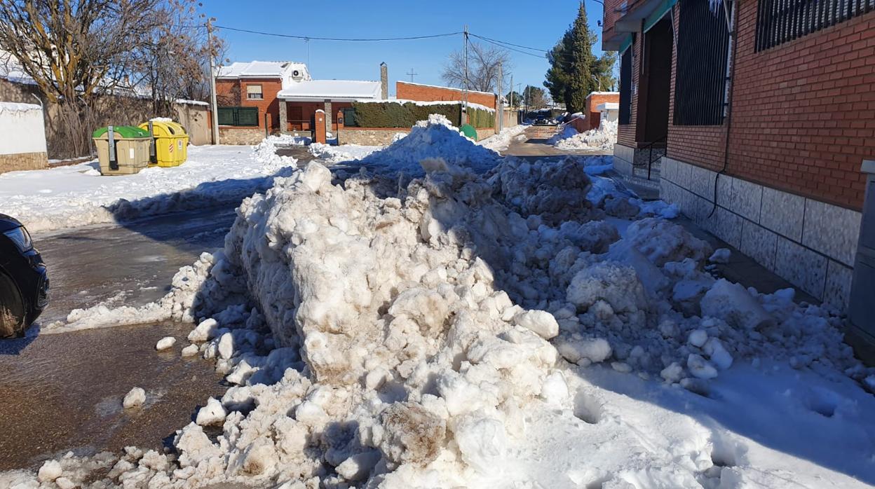 Una calle de Villanueva de Bogas, con montañas de nieve