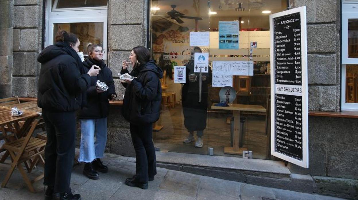 Un grupo de jóvenes, ante un local de hostelería, este miércoles en Santiago