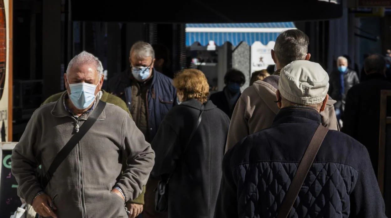 Imagen de personas con mascarilla por el coronavirus paseando por la calle en Alicante