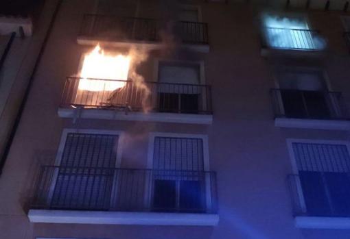 El fuego, saliendo por el balcón del dormitorio donde se produjo el incendio