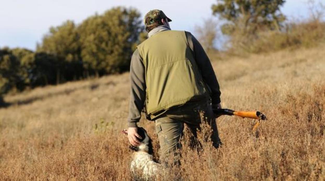 Un cazador acaricia a su perro