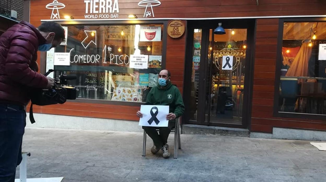 Los dueños de los bares se han sentado delante en la calle con carteles protesta por la situación que vive el sector