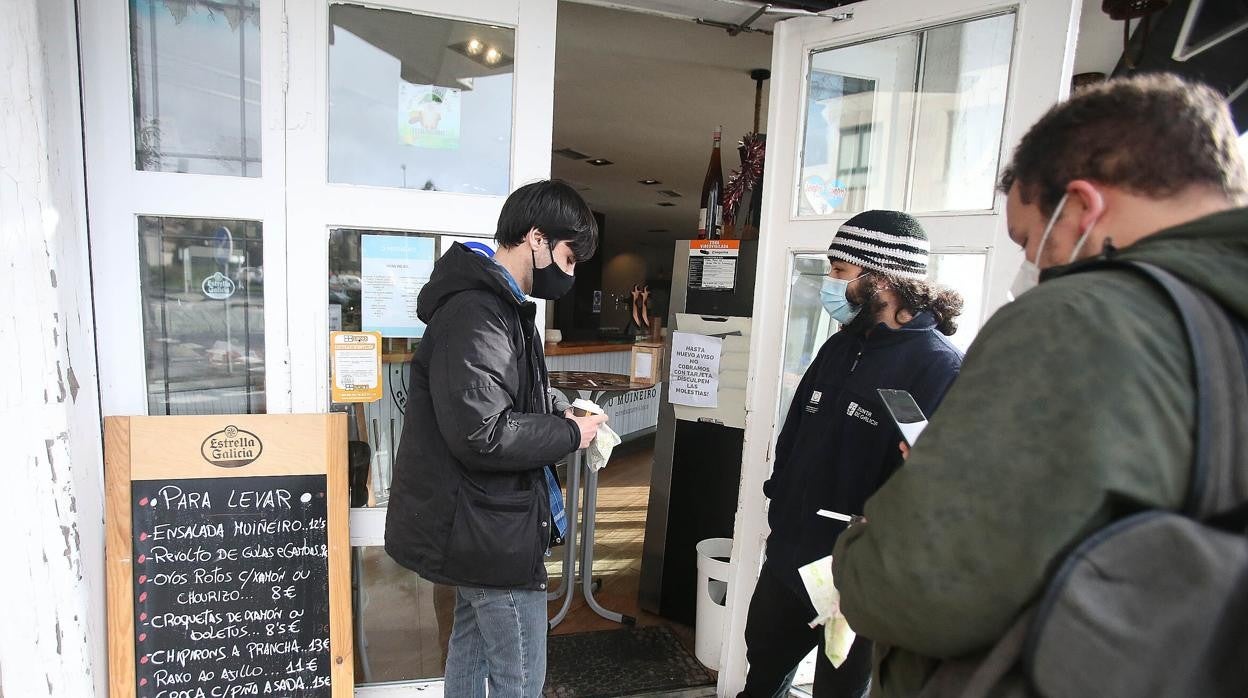 Un grupo de clientes, ante un local de hostelería, que solo opera con productos para recoger o entregar