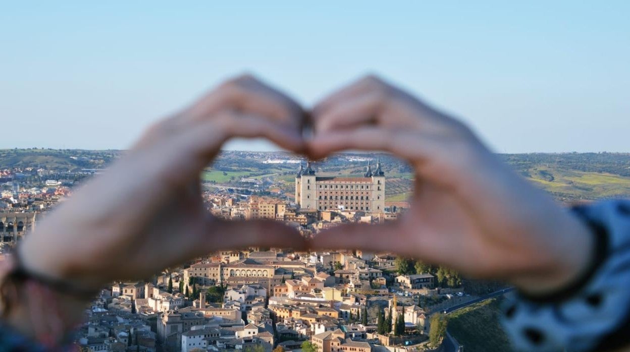 Su hija Inés forma un corazón con sus manos y, al fondo, el casco viejo y el alcázar