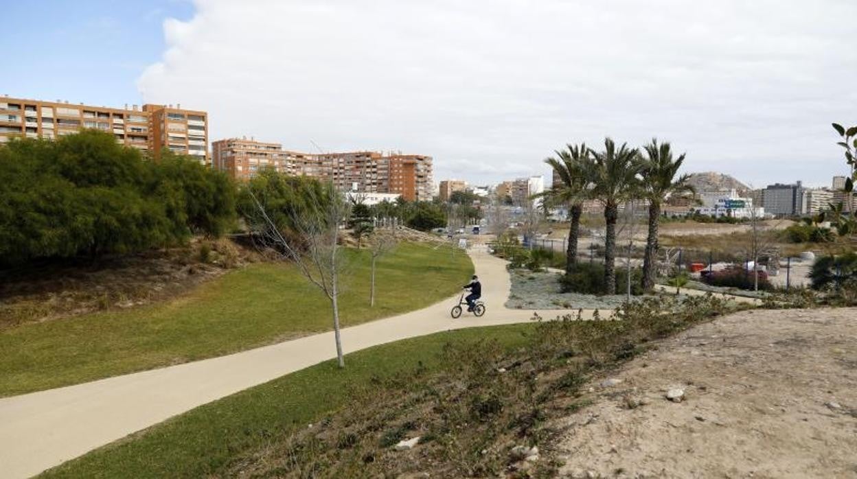 Un ciclista recorre una zona verde del área portuaria de Alicante