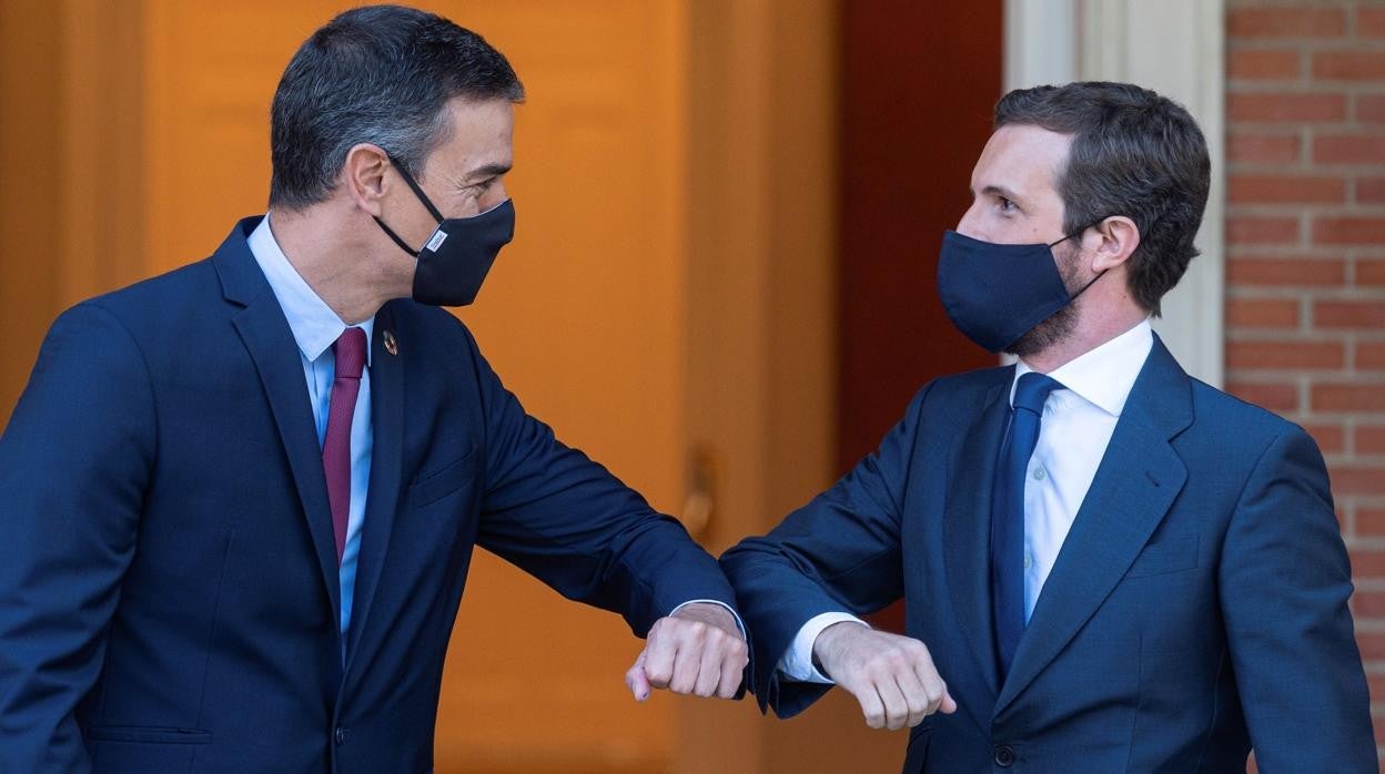 El presidente del Gobierno, Pedro Sánchez (izd.), y el líder de la oposición, Pablo Casado, (dcha.) se saludan a la entrada del Palacio de La Moncloa