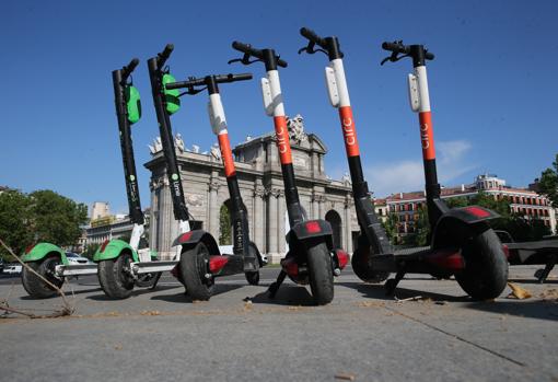 Varios patinetes estacionados en la plaza de la Independencia, junto a la Puerta de Alcalá