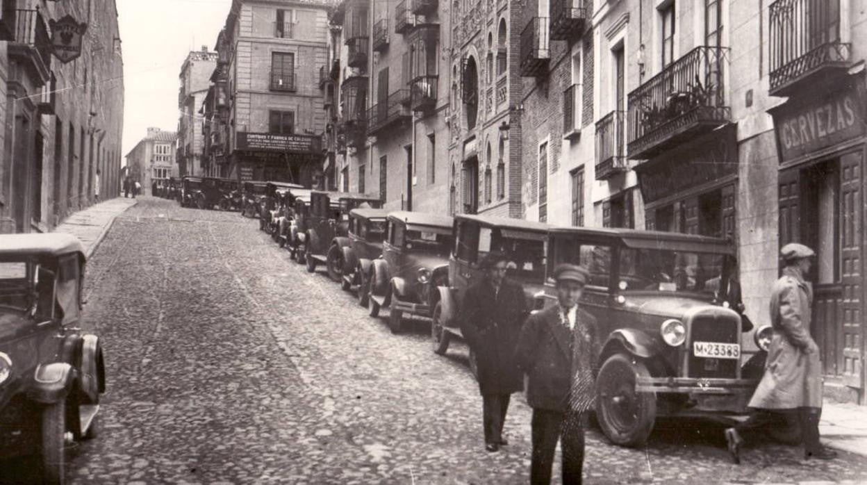 Vehículos en la cuesta de Carlos V, aún empedrada, hacia 1932. En su arranque inferior se aprecia el adoquinado que, en 1912, solo se aplicó a las calzadas que bordeaban el paseo central de Zocodover. Archivo Histórico Provincial de Toledo. Fondo Rodríguez