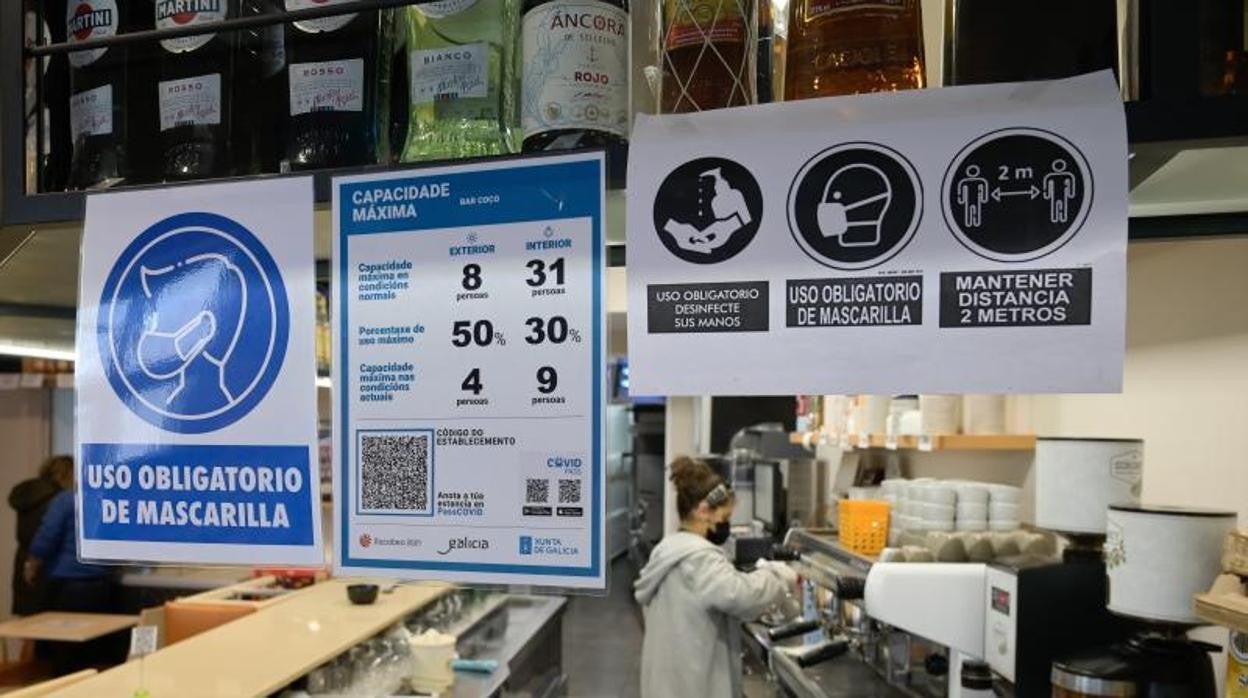 Carteles con los aforos y el código QR en un restaurante coruñés