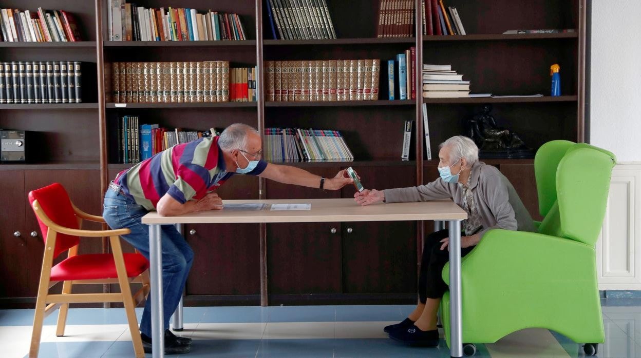 Un familiar visita a una anciana en una residencia