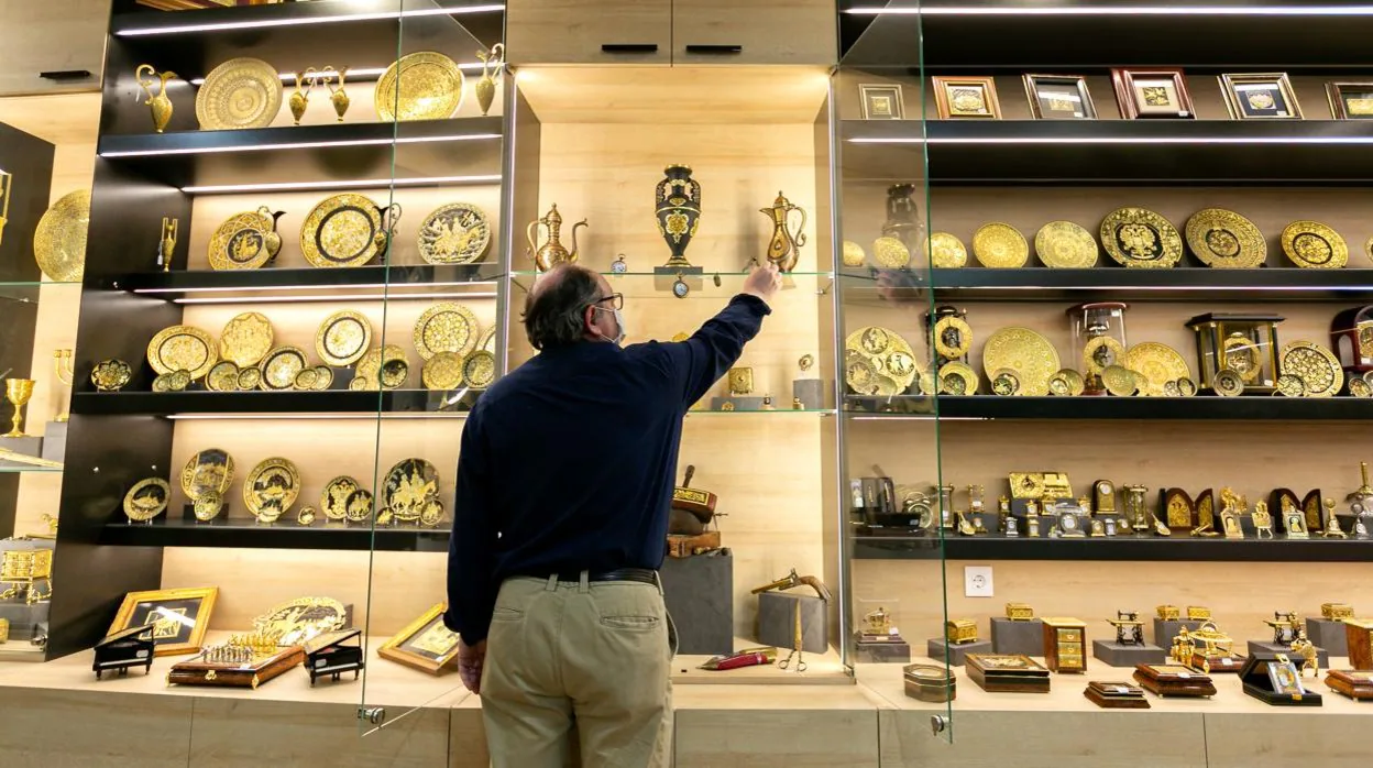Julián Oliva, un comerciante de artesanía del Casco antiguo de Toledo, coloca una pieza en su tienda