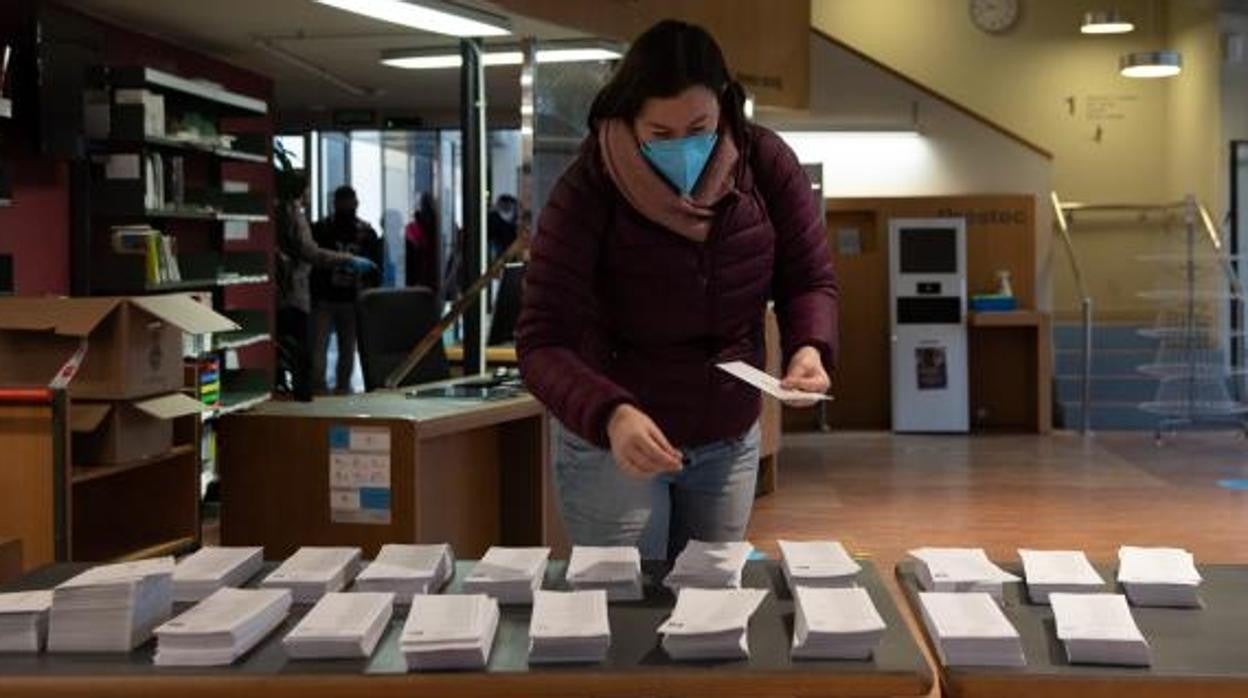 Una ciudadana elige su papeleta para votar en las elecciones catalanas, el pasado mes de enero