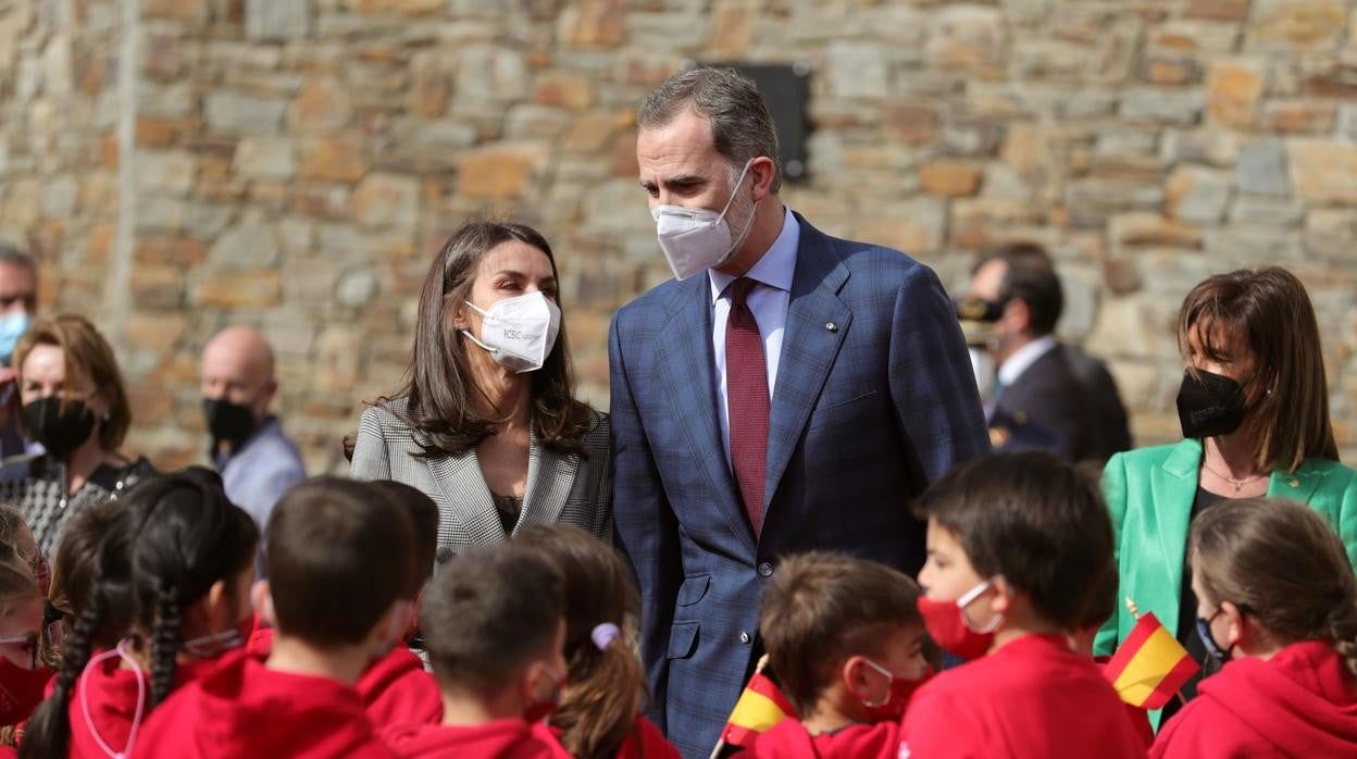 Los reyes Felipe VI (c-d) y Letizia (c-i) saludan a varios niños durante su visita al colegio «María Moliner»