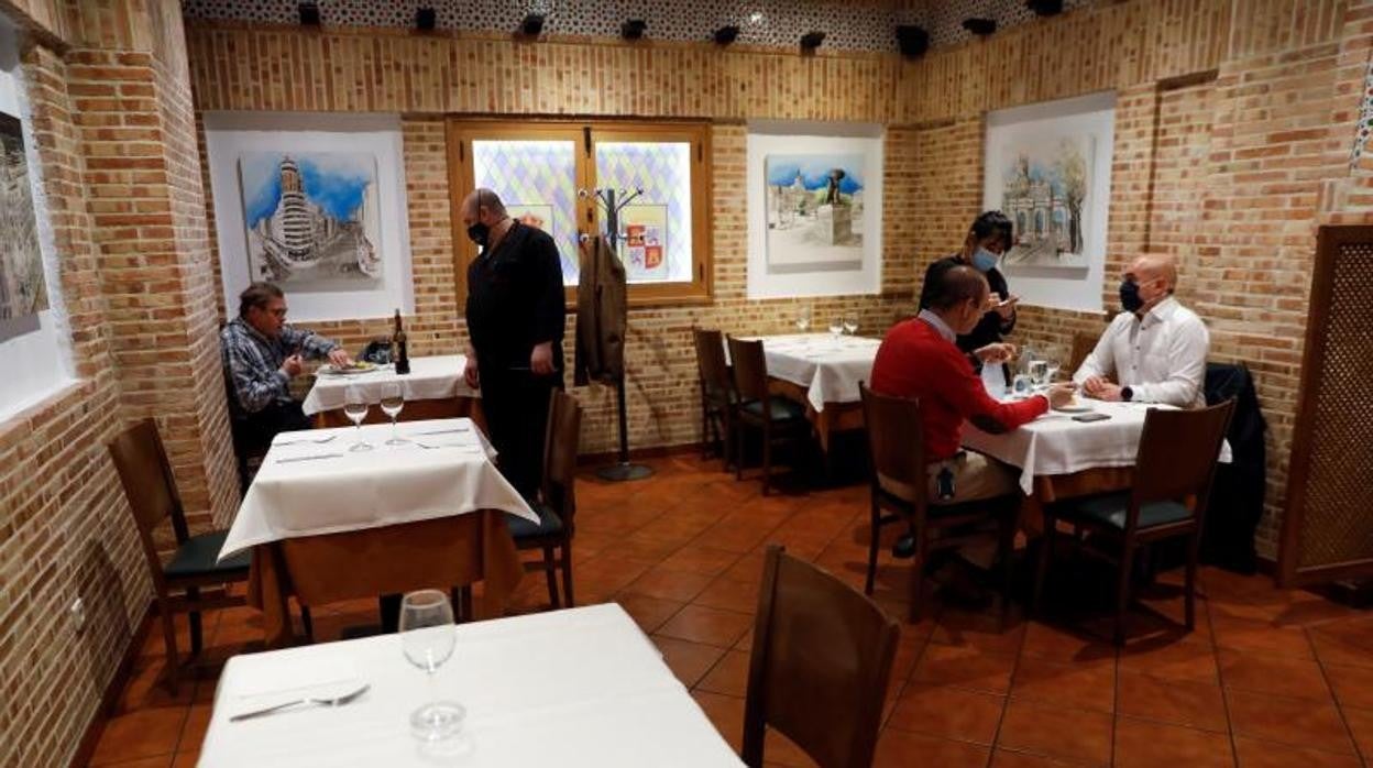 Usarios con mascarilla en el interior de un restaurante madrileño