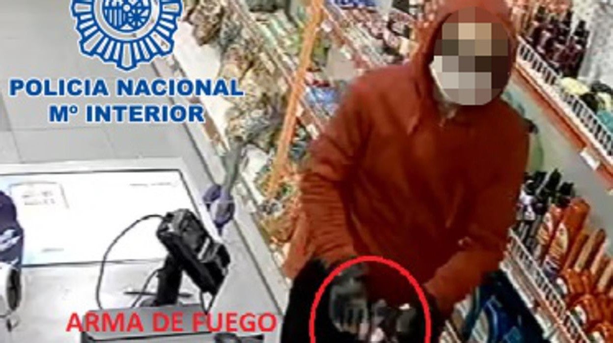 El ladrón, con el arma de fuego en sus manos