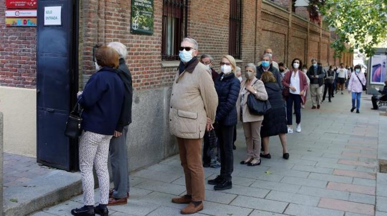 Varias personas hacen cola para ejercer su derecho al voto en el colegio electoral de Nuestra Señora de Loreto