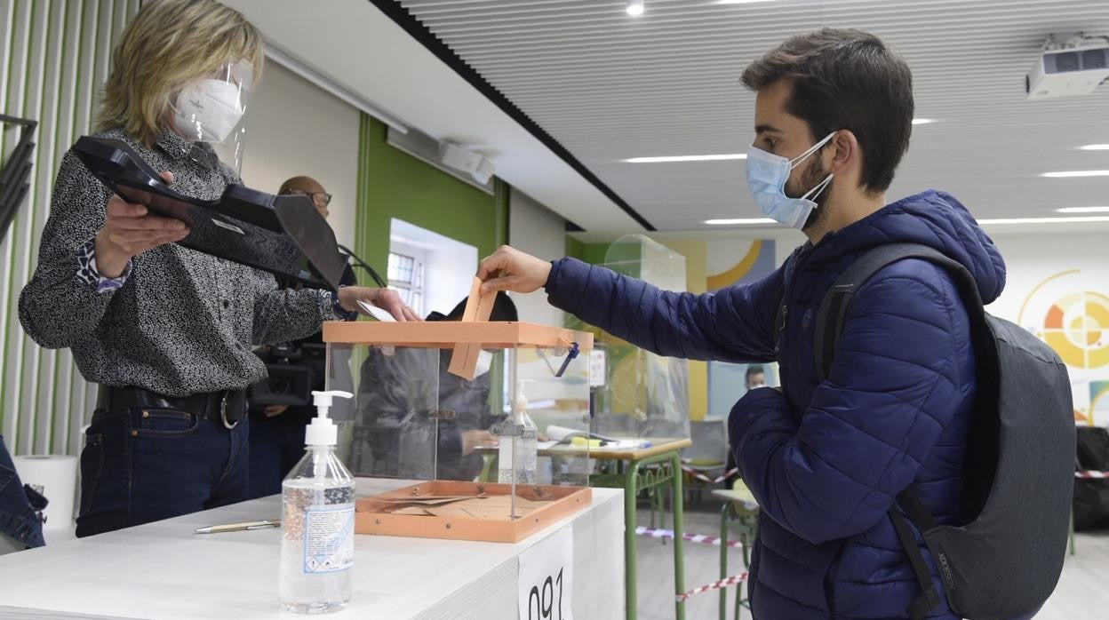 Un joven vota, este martes, en el colegio La Inmaculada Marillac (Chamberí)
