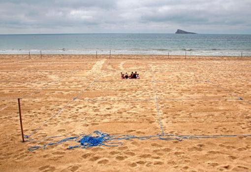 Imagen de la arena parcelada para garantizar la distancia de seguridad por el coronaviruss, con la isla de Benidorm al fondo