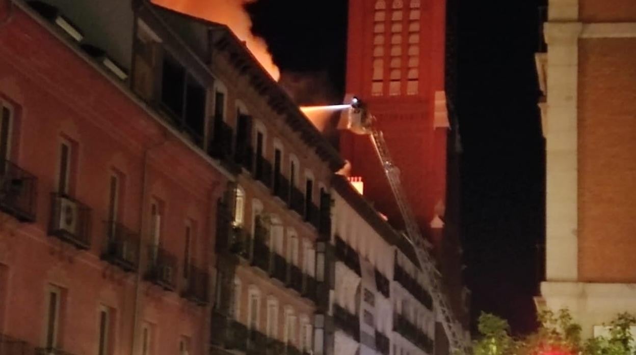 Un bombero sofoca las llamas del incendio en la calle Espoz y Mina