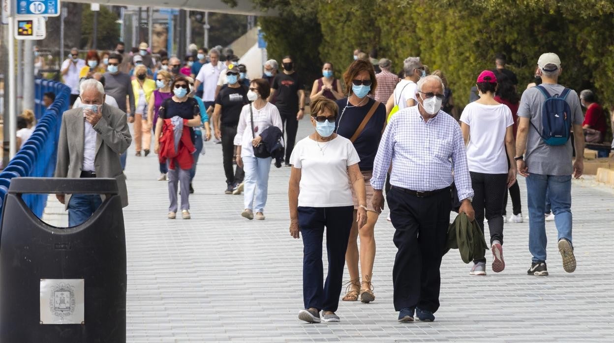 Imagen de personas paseando cerca de la playa del Postiguet de Alicante