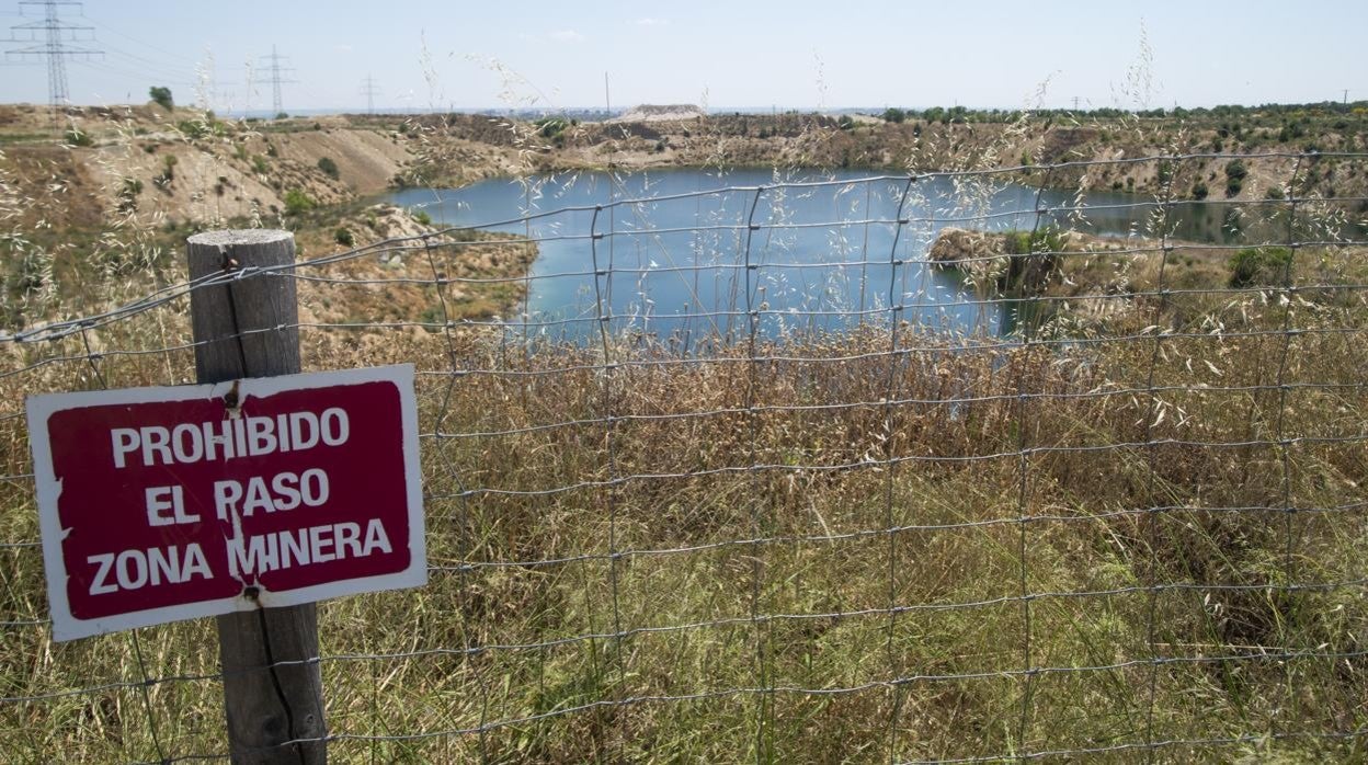 La destartalada valla, con carteles de advertencia, que rodea al hueco minero de Ambroz