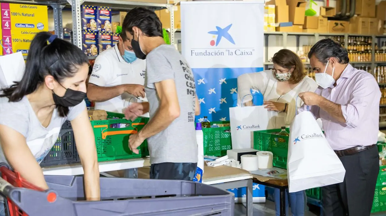 Varios voluntarios colaboran en un banco de alimentos colaborador con la Fundación 'la Caixa'